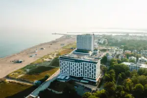 Das aja Warnemünde neben einem Strand aus der Vogelperspektive.