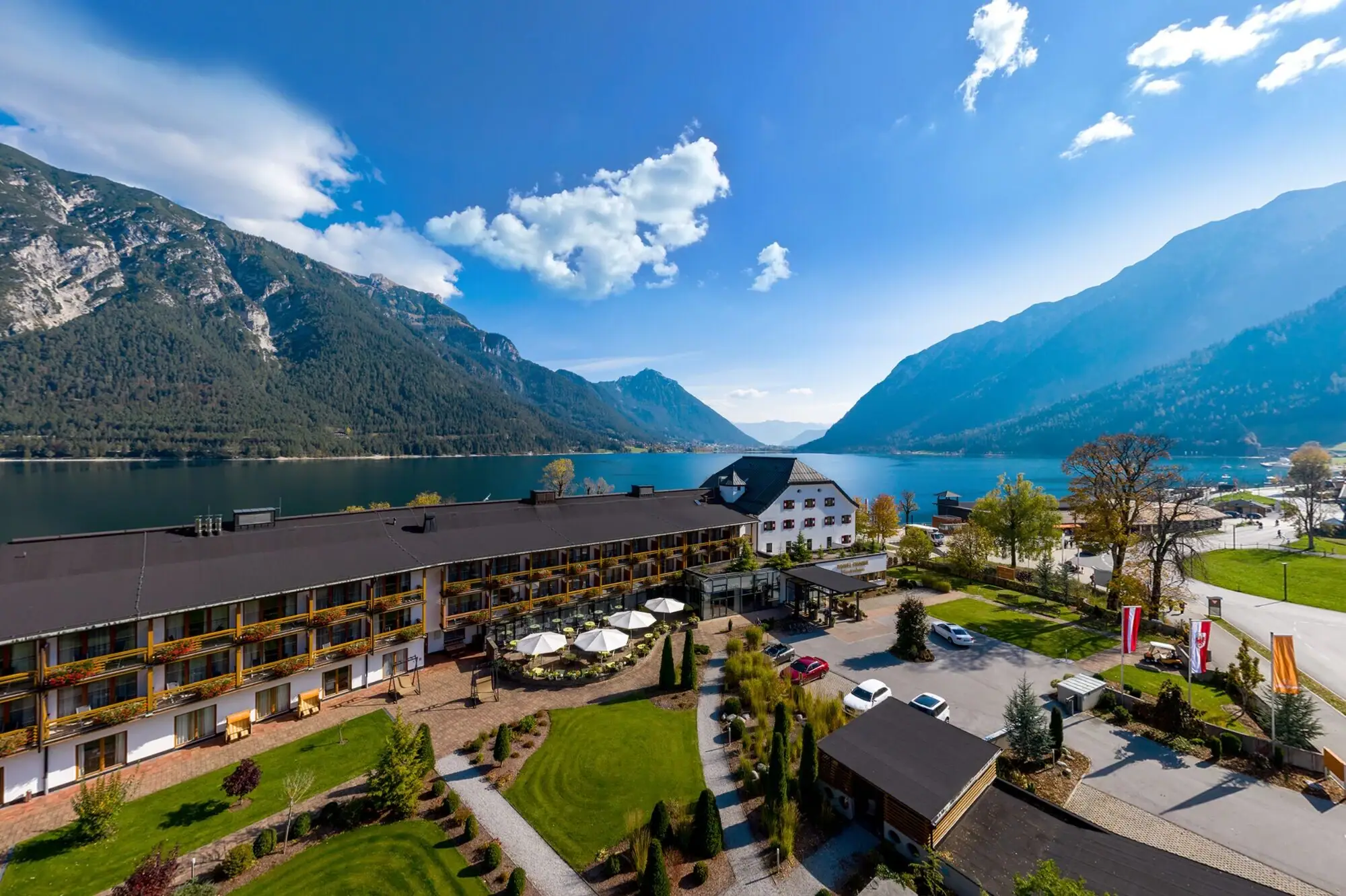 The aja Fürstenhaus on Lake Achensee photographed from a bird's eye view with Lake Achensee and mountains directly behind it.