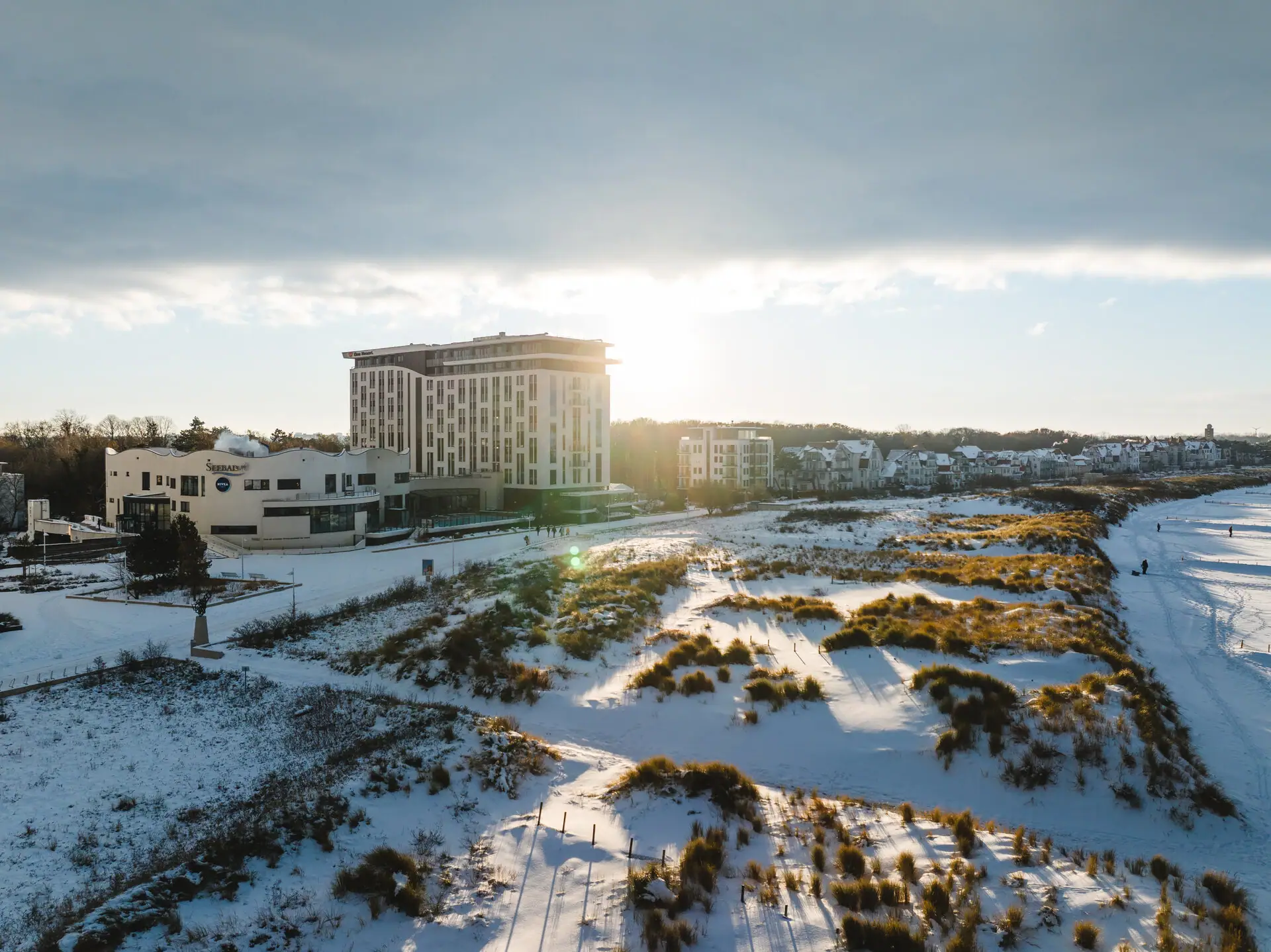 Ein schneebedecktes Feld mit dem aja Warnemünde im Hintergrund.