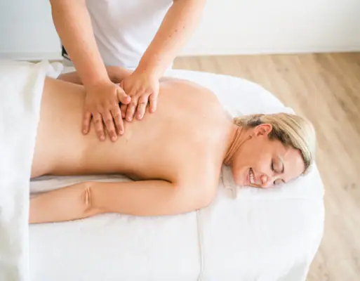 A woman lies on a massage table.