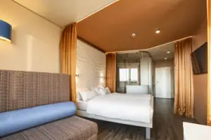 Rooms at the aja Warnemünde A room with a bed and a sofa.