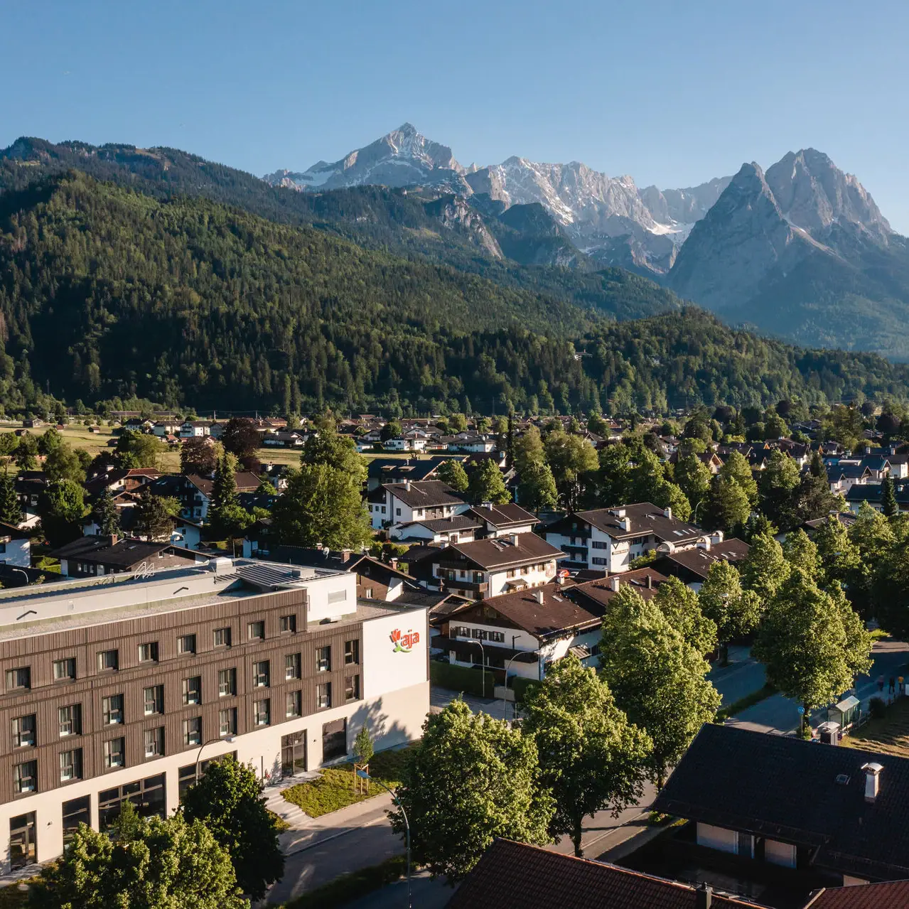 aja Garmisch-Partenkirchen A city with trees and mountains in the background.