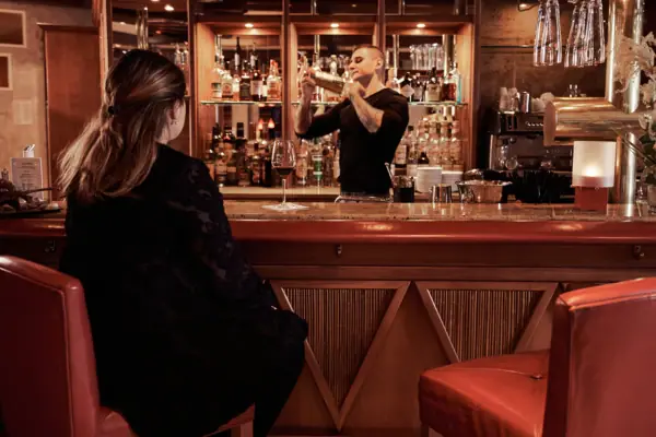 Bistro & Bar Patio A man and a woman in black dresses are sitting at a bar.