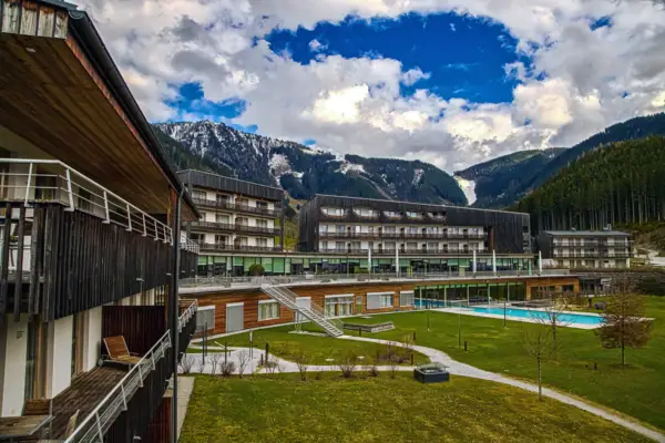 A hotel building with a swimming pool in front of it.