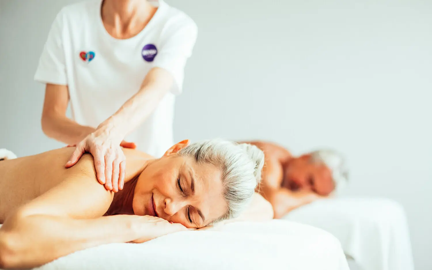 A relaxing spa scene with a person enjoying a soothing back massage, showcasing the tranquil and luxurious atmosphere of the wellness area.