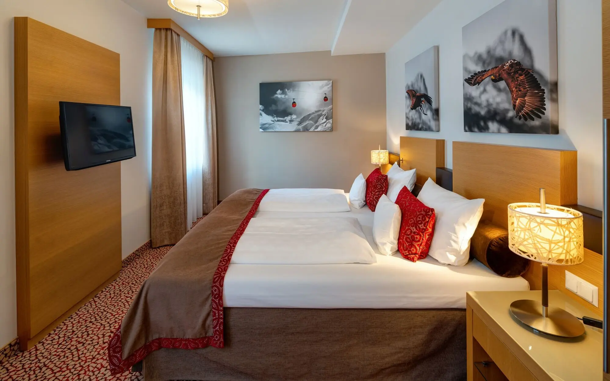 Interior of a bedroom with a bed and a television.