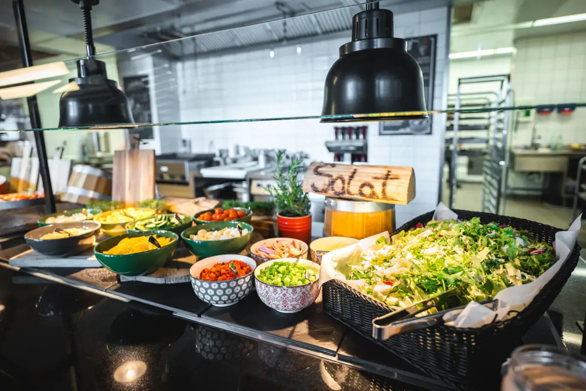 Buffet table with various bowls full of dishes, salads and dressings.