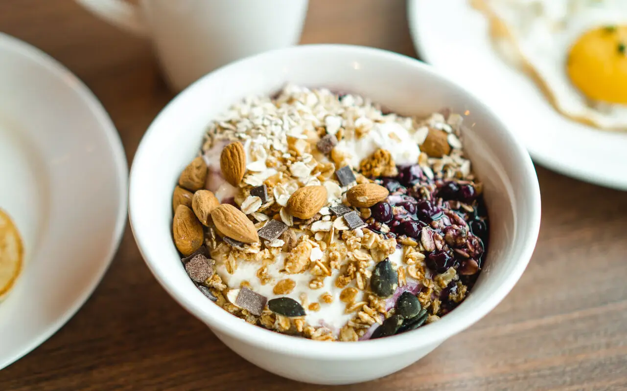 A bowl of yogurt and granola on a table.