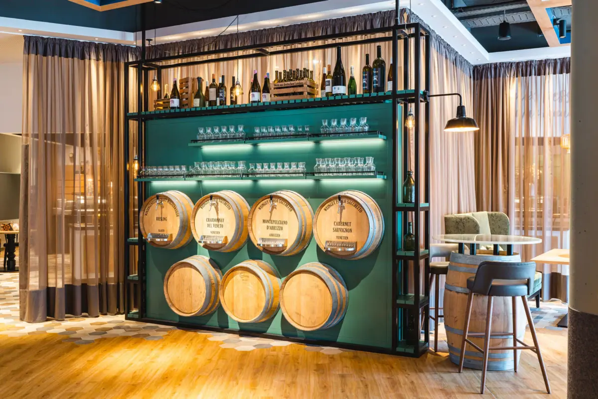 A room with wine barrels and glasses.
