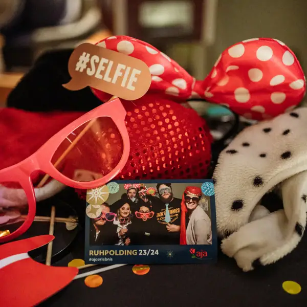 Accessories for a photo box on a table and a photo in the centre with people celebrating.