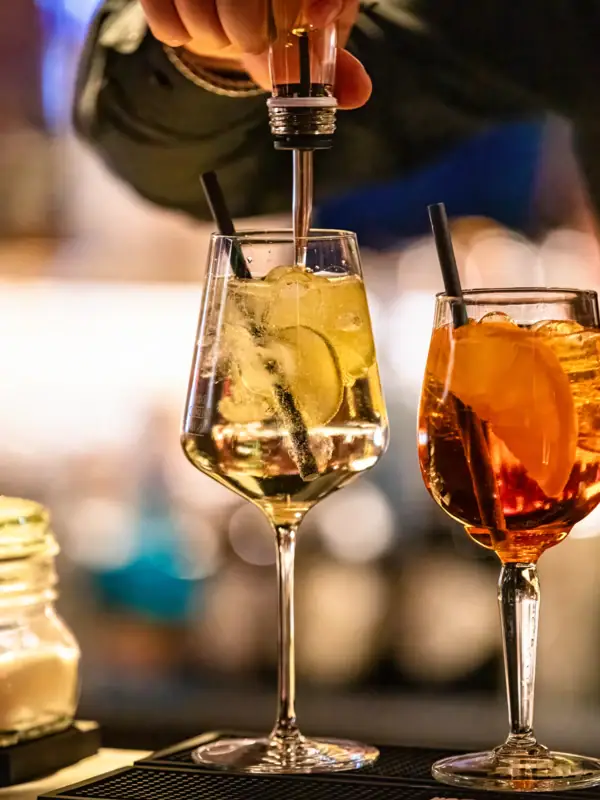 A person pours a drink into a glass.