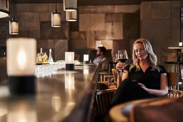Woman sitting at a bar holding a glass of wine.