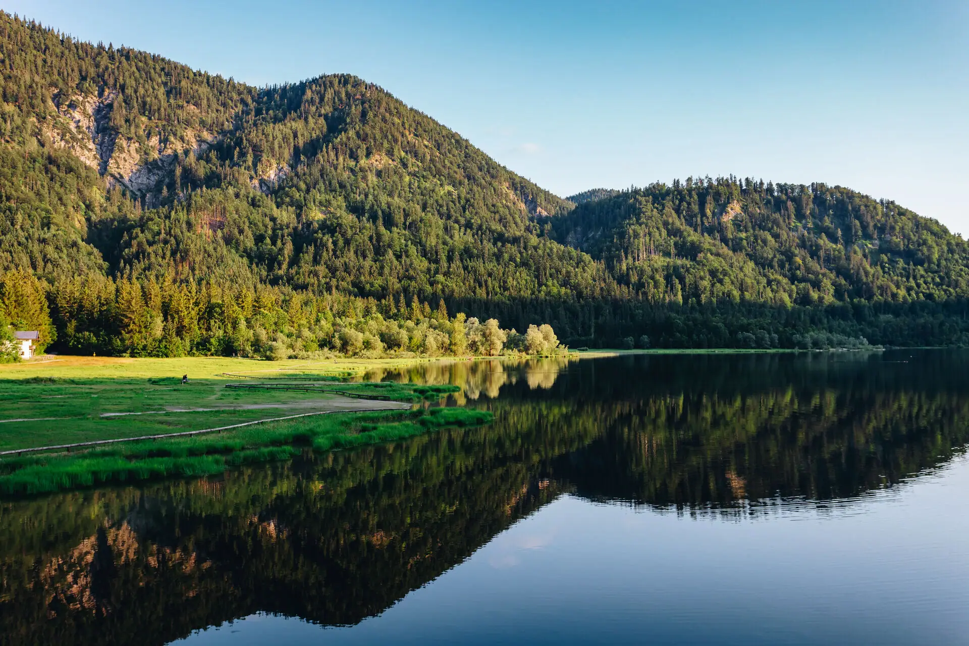 A lake with trees and mountains in the background.