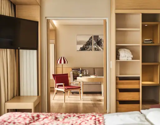 Hotel room Werfenweng A hotel room with a TV and a seating area with a sofa and chair.