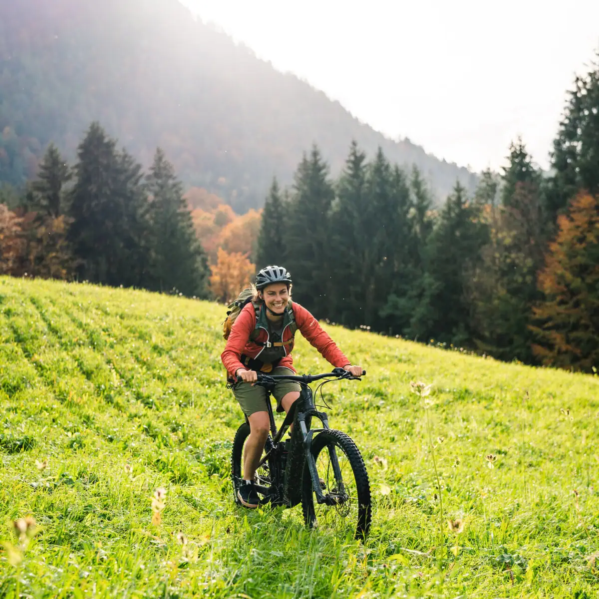 A man rides a bicycle across a grassy field.