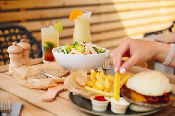 A salad and a plate with a burger and fries sit on a table in the aja Bar Garmisch-Partenkirchen.