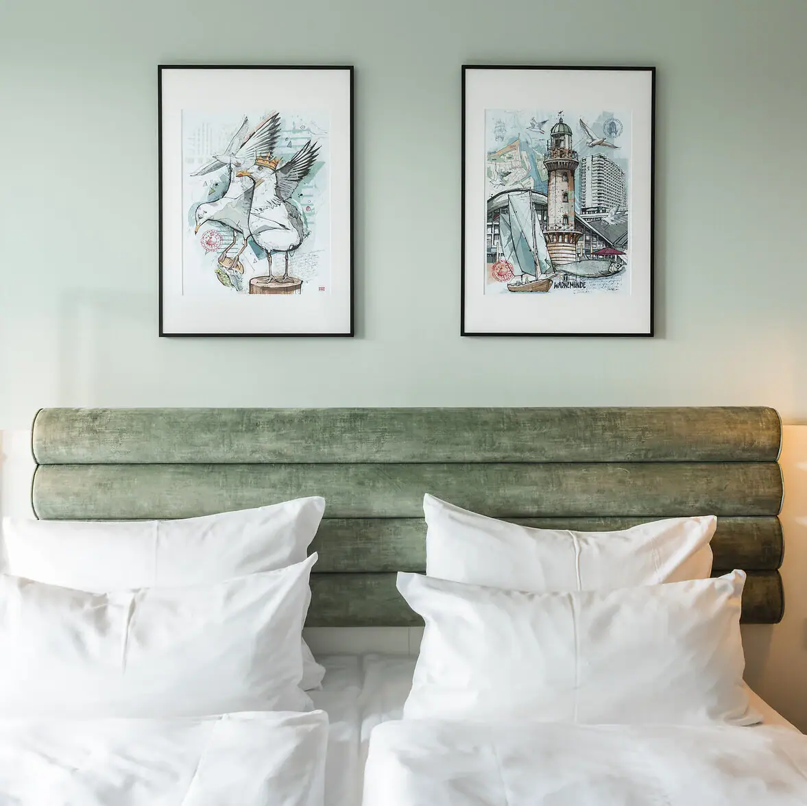 Rooms and suites at the aja Warnemünde Bed with white cushions and green headboard, flanked by two lamps.