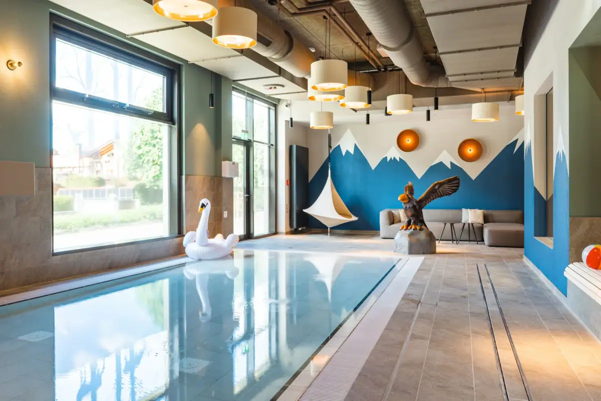 A swimming pool with a swan and a bird sculpture.