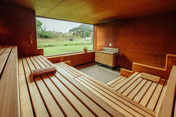 A room with a wooden bench and a barbecue.
