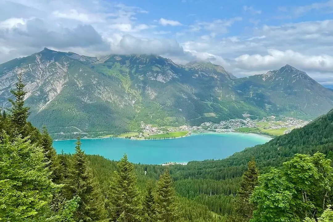 View of the Achensee A lake surrounded by trees and mountains.