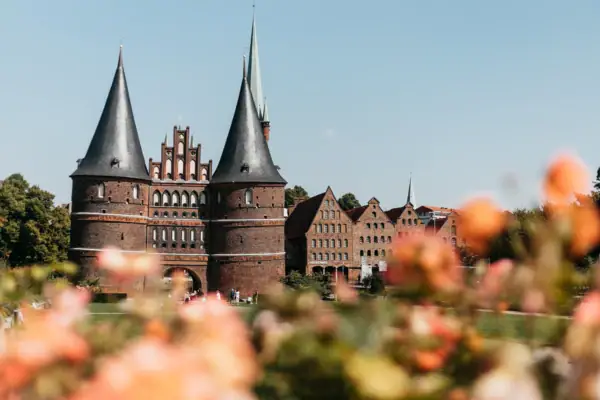 A building with towers and a lawn in the background.