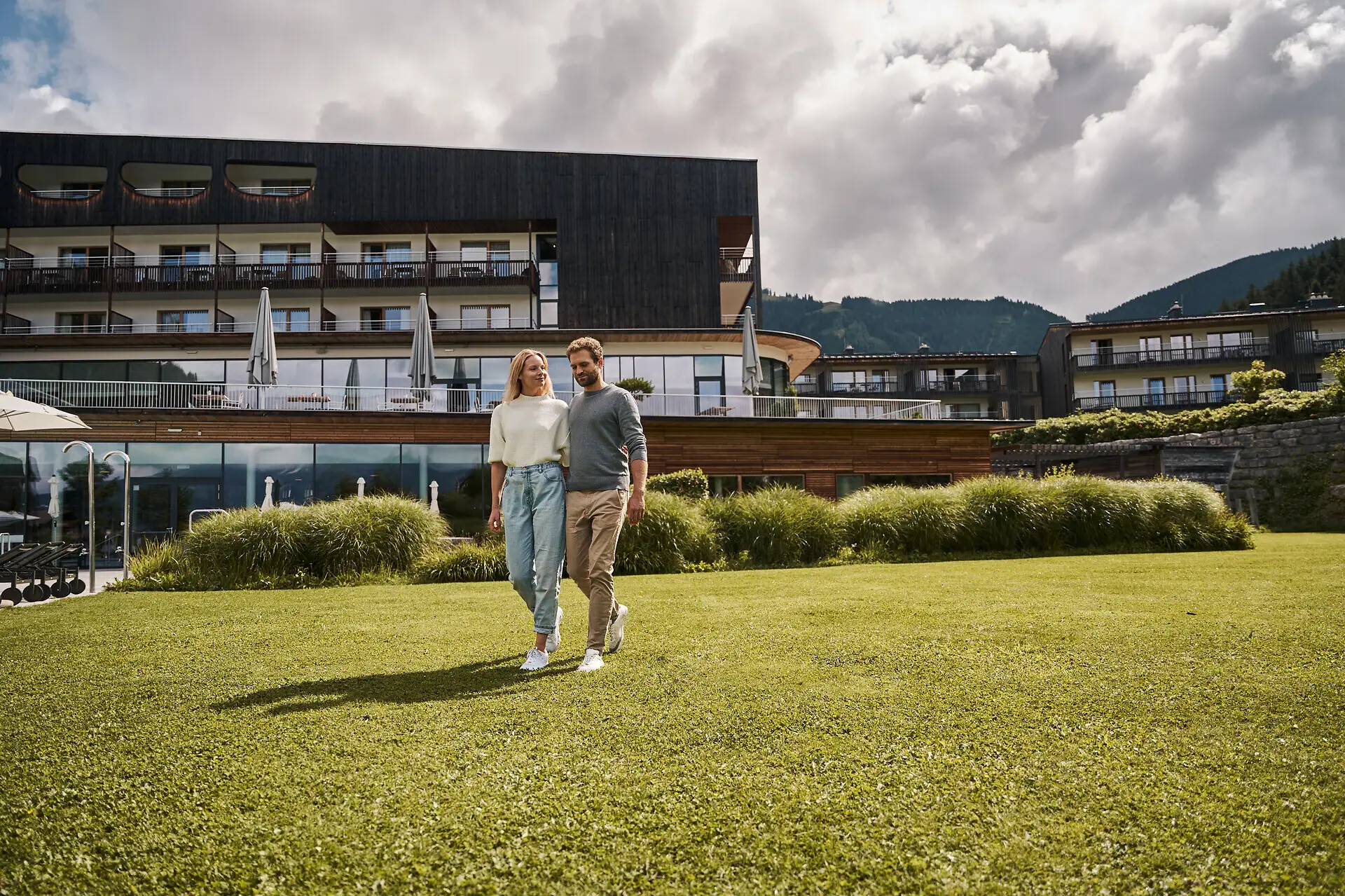 A man and a woman are walking on a lawn.