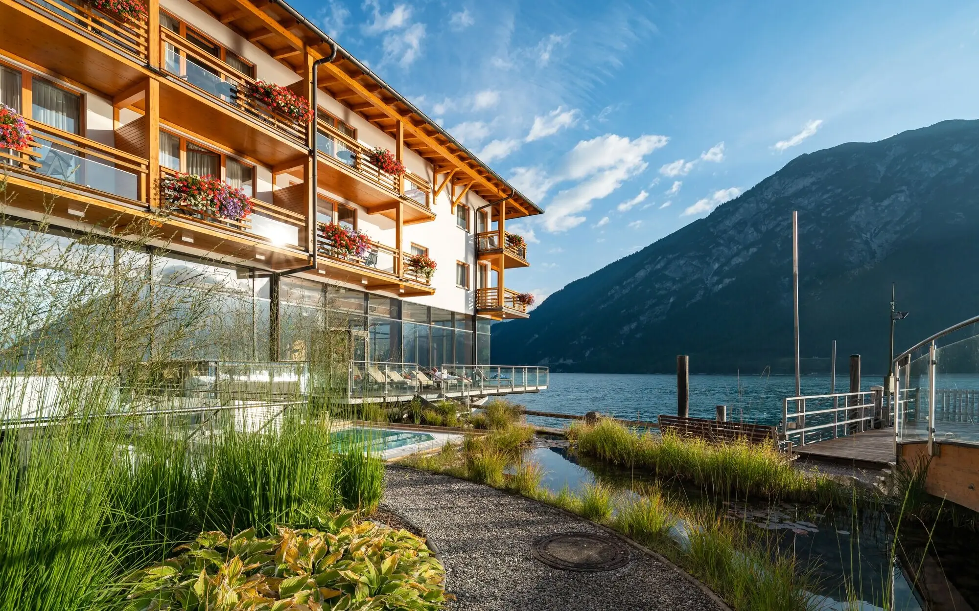 A building beside a lake with mountains in the background.