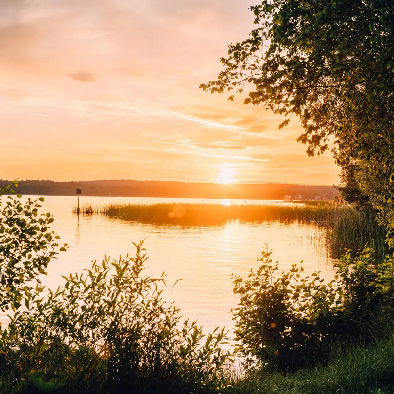 Sunset over a lake with clouds in the sky.