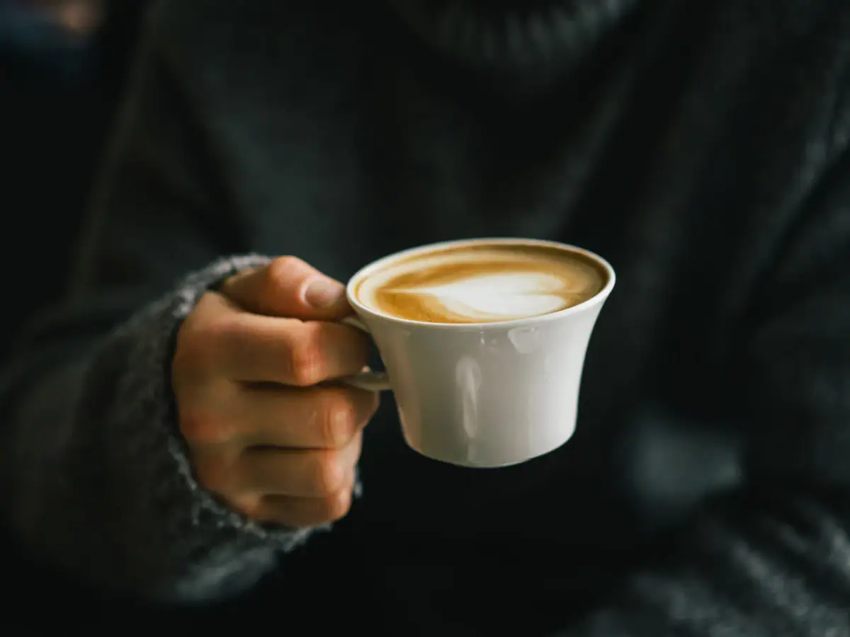 A person is holding a cup of coffee.