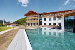 A swimming pool in front of a building, with a clear sky in the background.