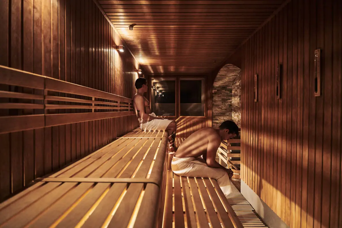 Group of men sitting on benches in a sauna