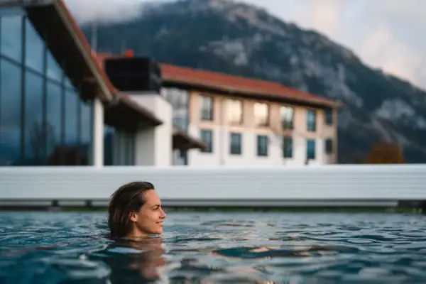 A woman in the pool with a building in the background.