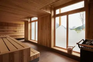 A room with a wooden bench and windows.