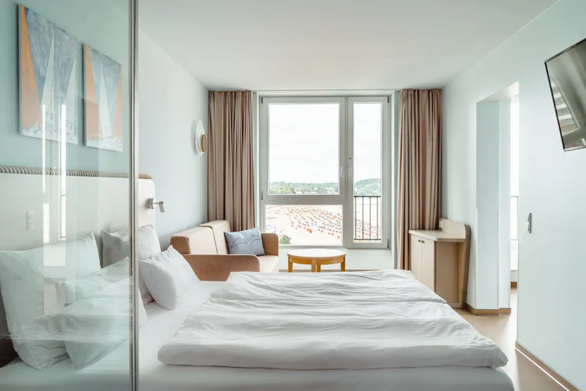 A room with a bed, a chair and a table.