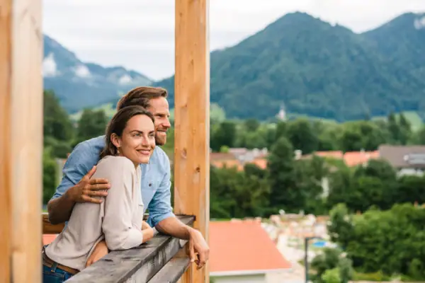 Balcony Ruhpolding A man and a woman lean against a railing outside.