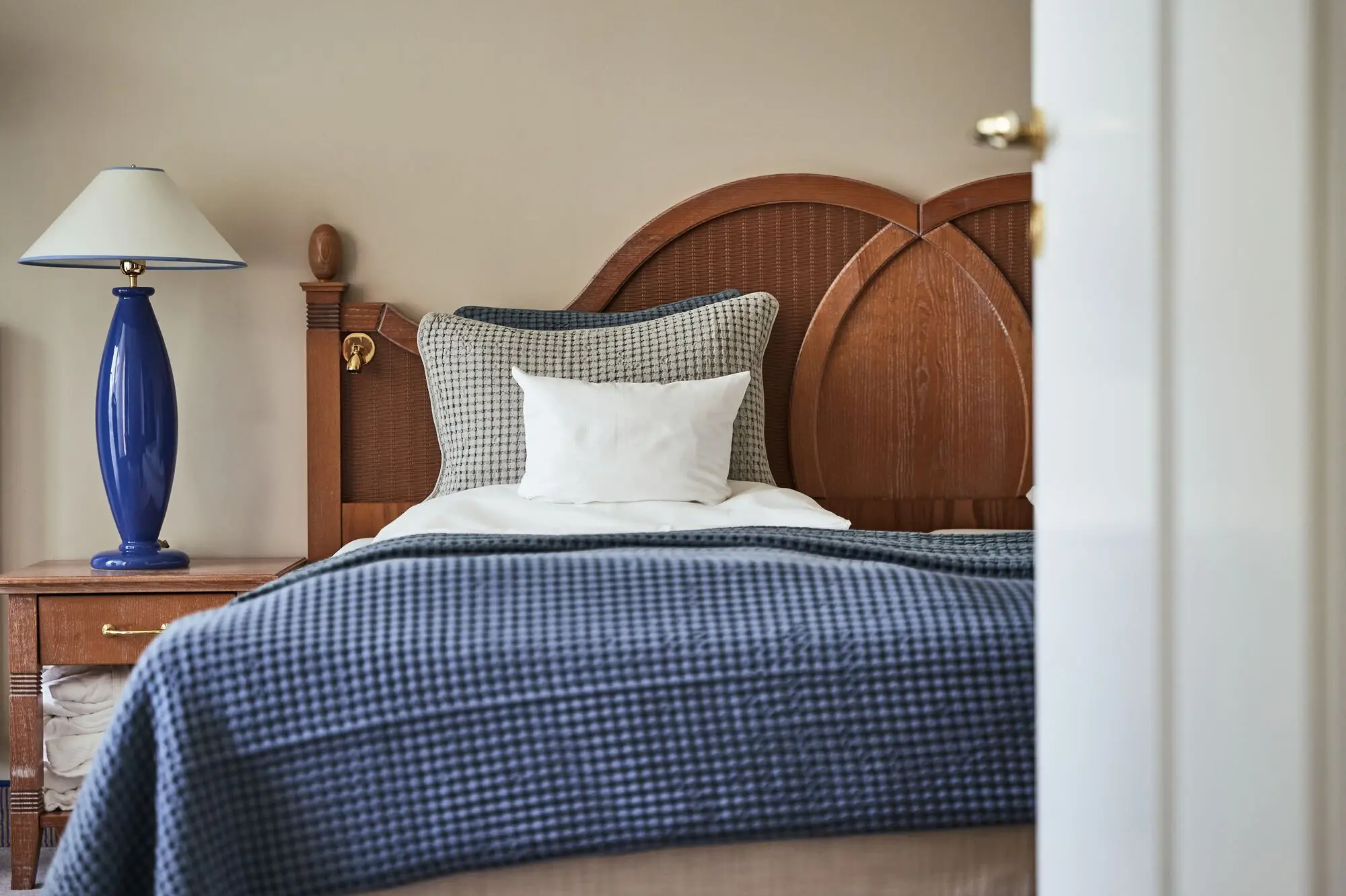 The view into a bedroom with a bed and a bedside table.