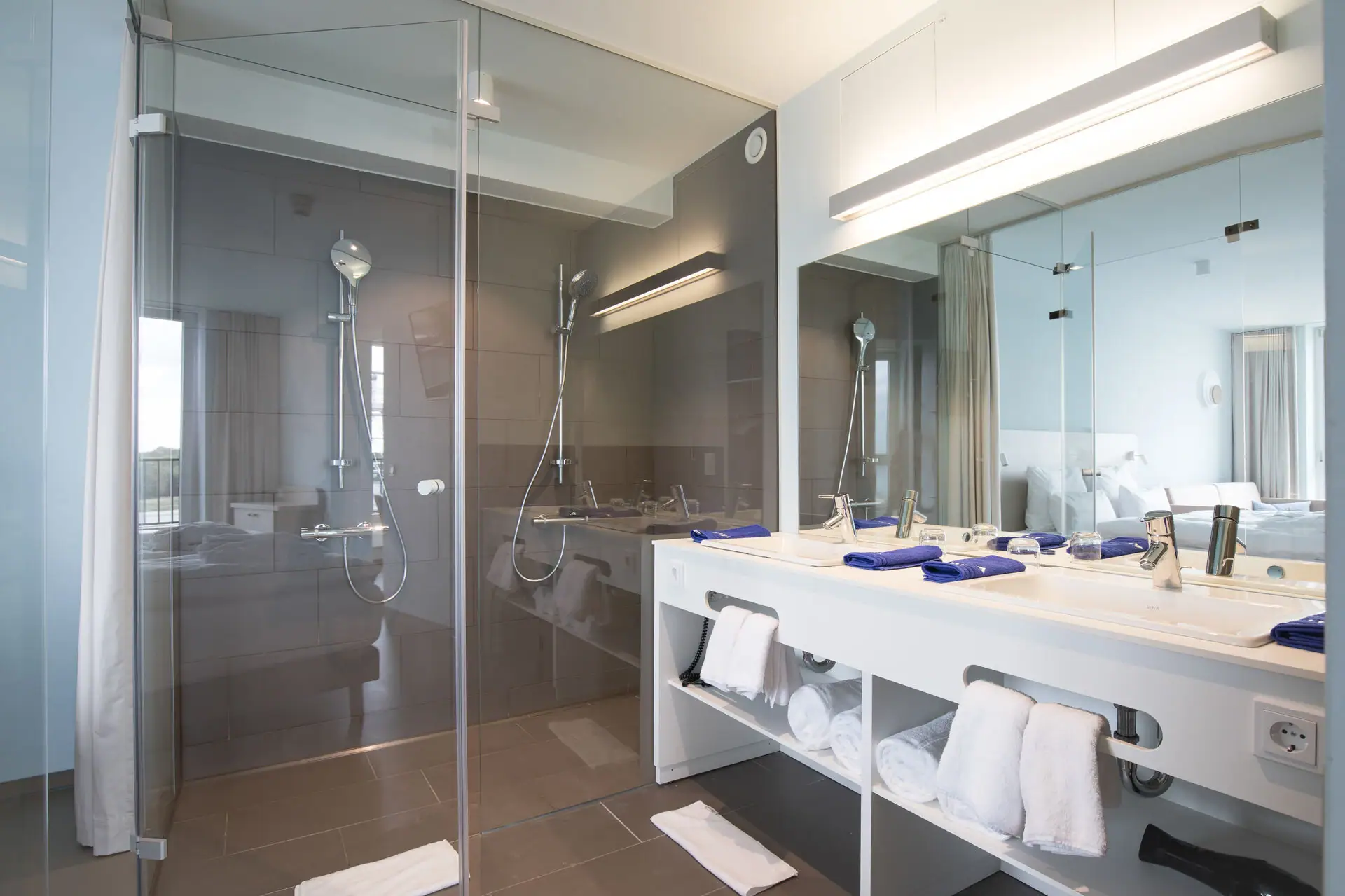 Suite at the aja Travemünde Bathroom with shower and large shower area.