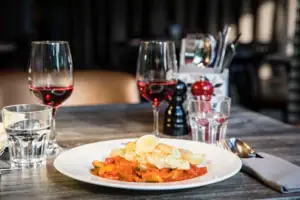 A plate of food and wine glasses on a table.