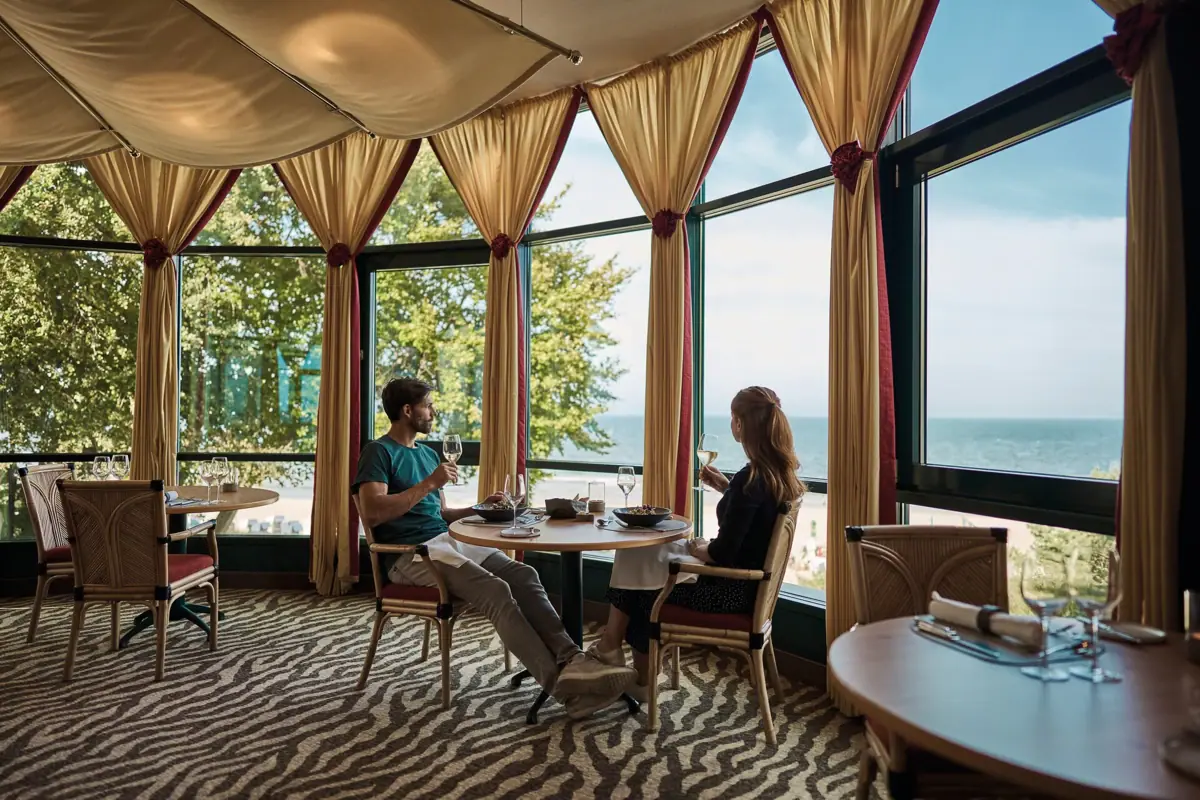 A man and a woman are sitting at a table with drinks.