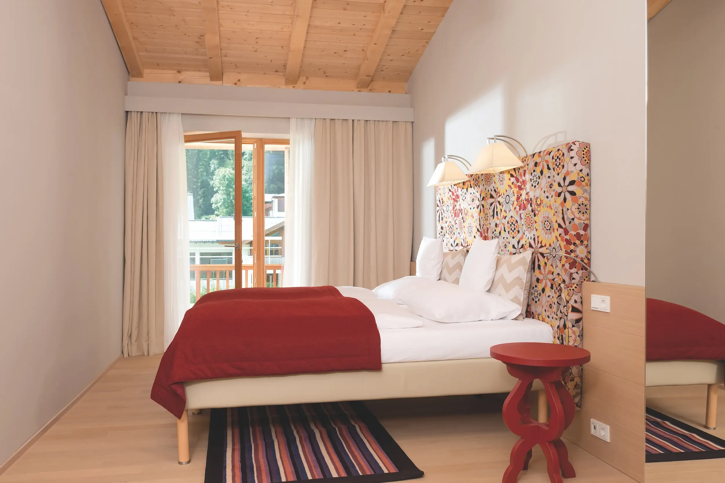 A bed with a colorful headboard in a room.