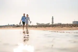 Ein Mann und eine Frau gehen am Strand entlang.