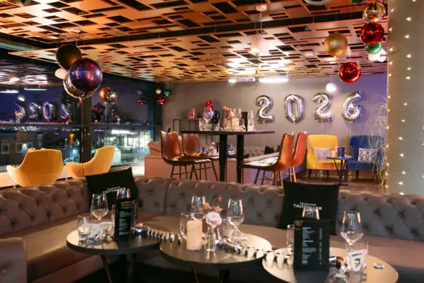 A room with a couch and colorful balloons.