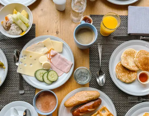 A table with plates full of food and drinks for breakfast