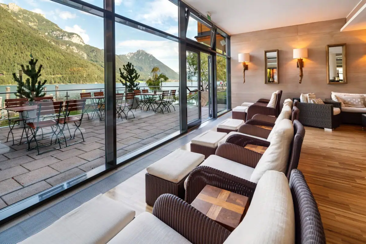 A room with tables and chairs offering a view of the mountains.