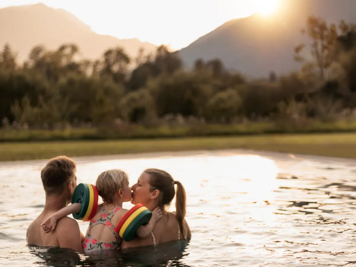 Parents with a child at the aja family hotel in Ruhpolding, Bavaria, swimming in the outdoor pool.