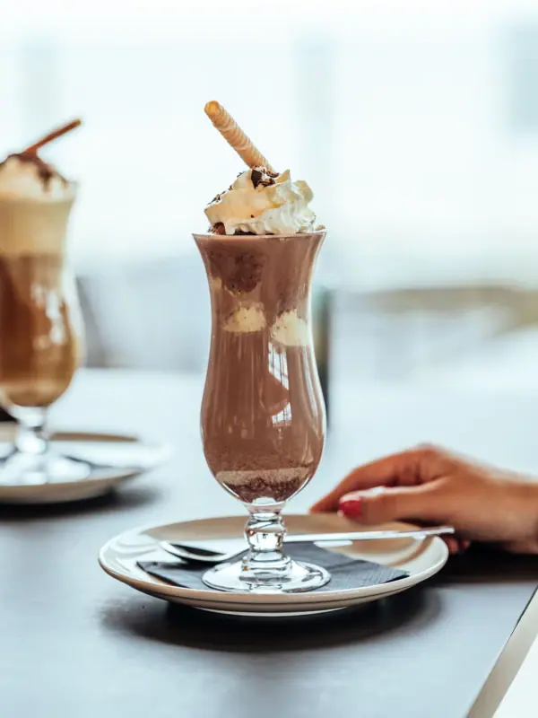 Chocolate ice cream A glass of chocolate milkshake with whipped cream and waffles.
