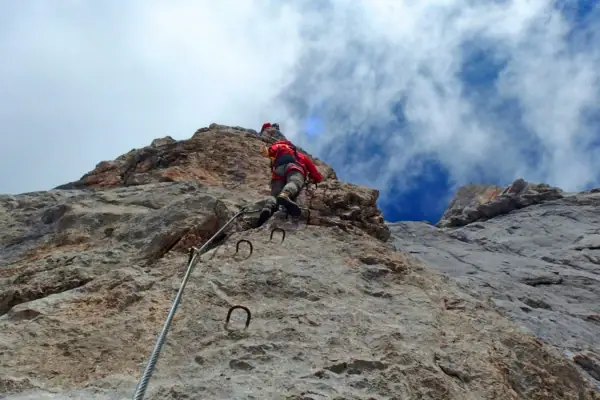 A person climbs up a rock face.