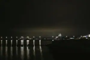 A body of water at night with lights.