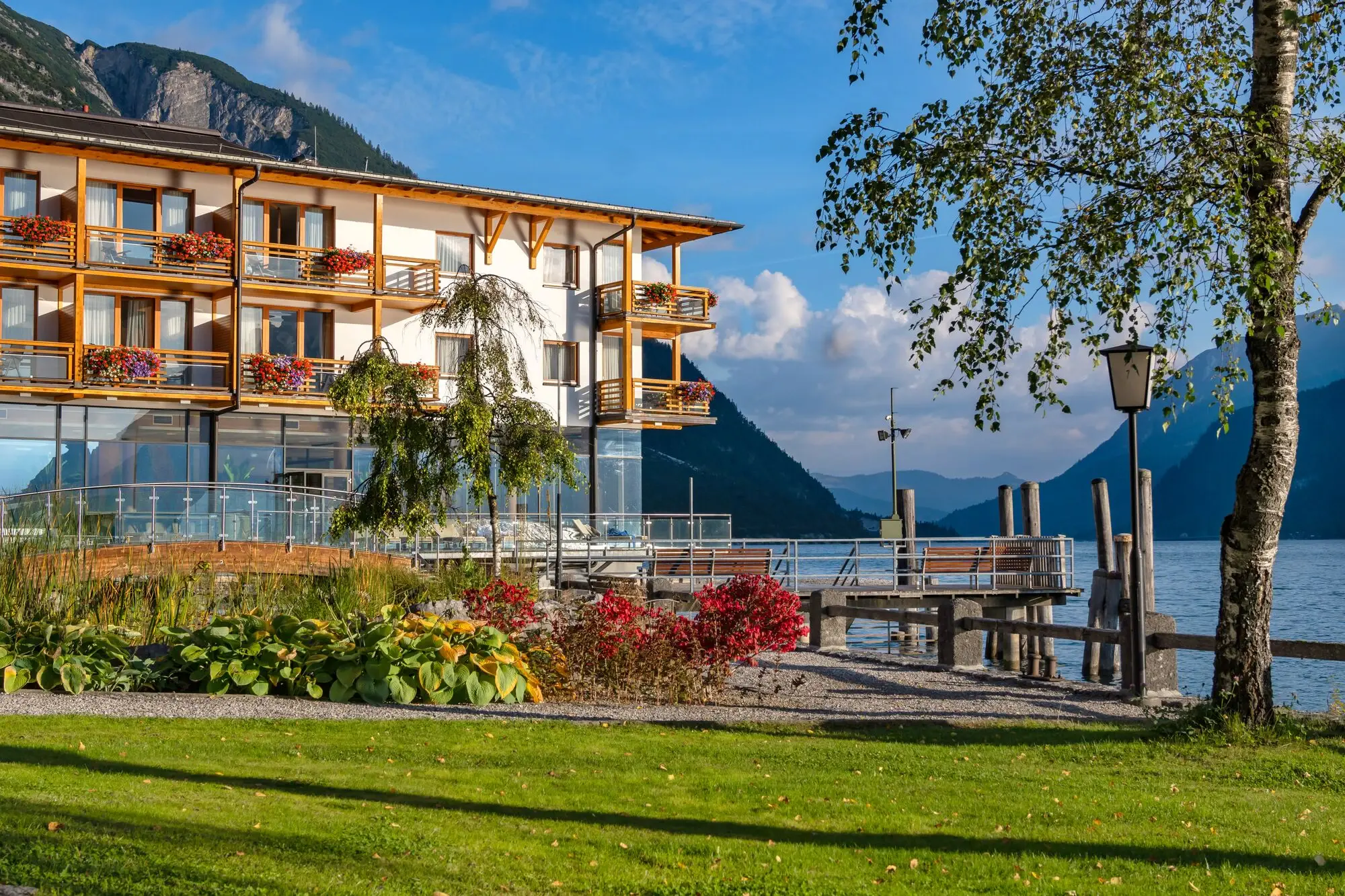 Building by the lake with mountains in the background.