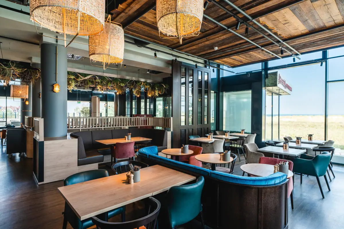 A restaurant with tables and chairs, furnished and decorated in a maritime style.